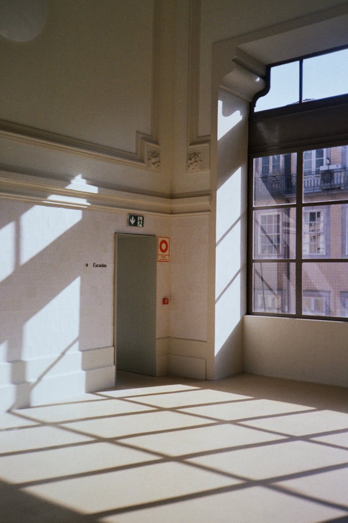 Sunlit room with architectural details and shadows, Porto, Portugal.